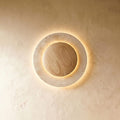 Lampada da parete circolare in travertino con nucleo in legno e luce indiretta delicata