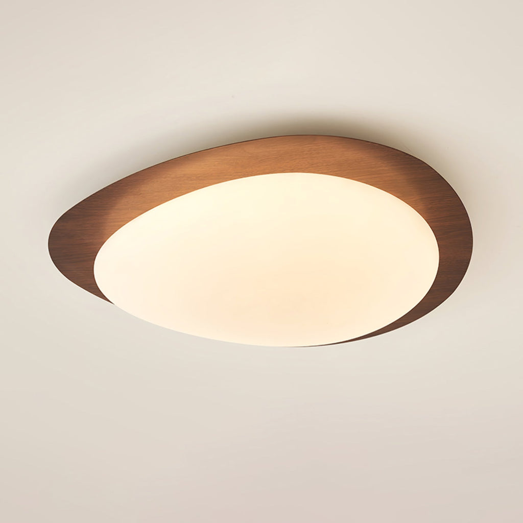 Loftslampe med rullestensinspireret silhuet, valnøddetræsfinish med synlig åretegning og varmt skær