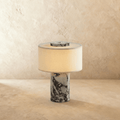 Lampada da tavolo Solstice con base in pietra e paralume in tessuto morbido