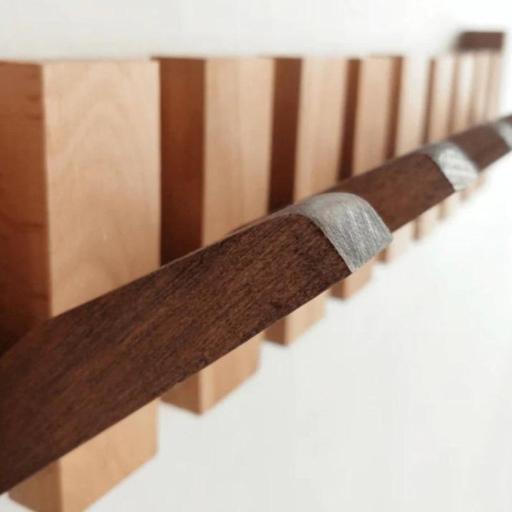Appendiabiti da parete in legno con fila di ganci a forma di tasti di pianoforte