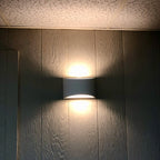 Lampada da parete AuroraCurve in gesso con luce soffusa verso l'alto e verso il basso