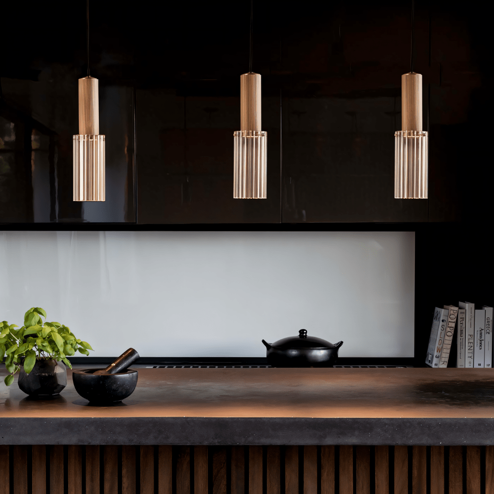 Langwerpige koperen hanglamp met geribbelde glazen kap en warme gloed