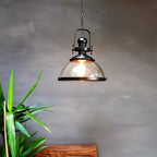 Lámpara colgante industrial vintage de metal negro con cúpula de vidrio y bombilla expuesta  